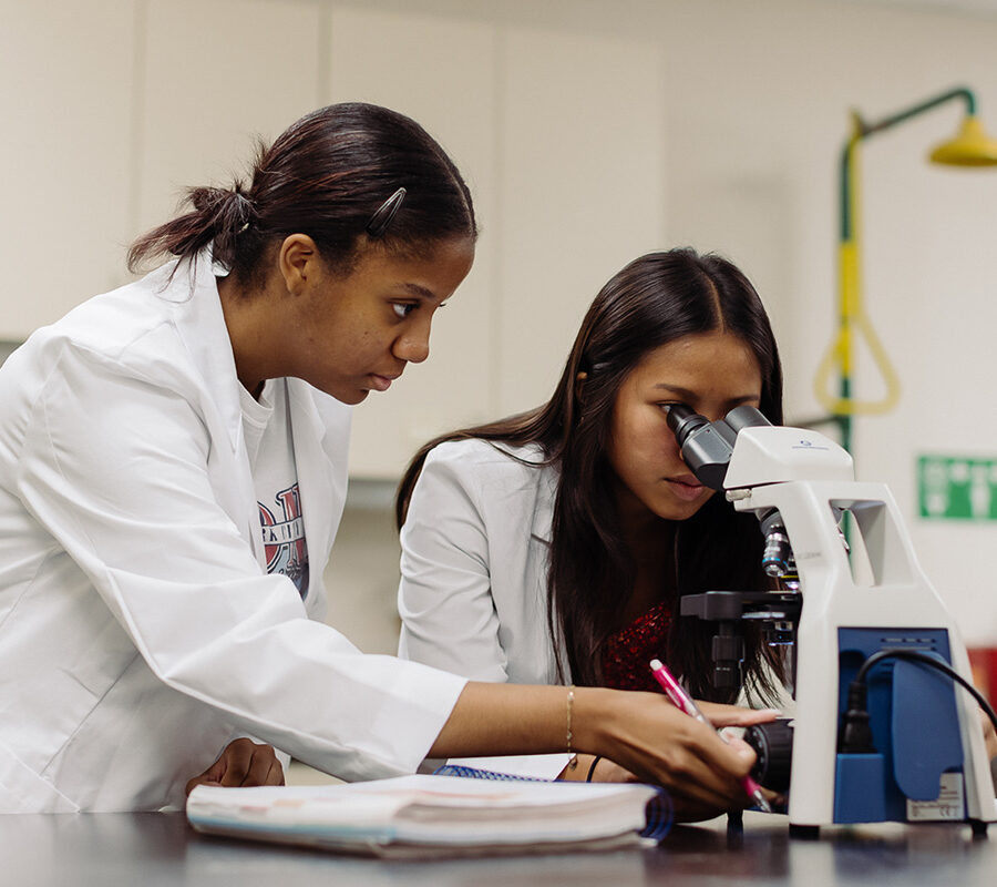 biology and health science students in a laboratory looking into a microscope