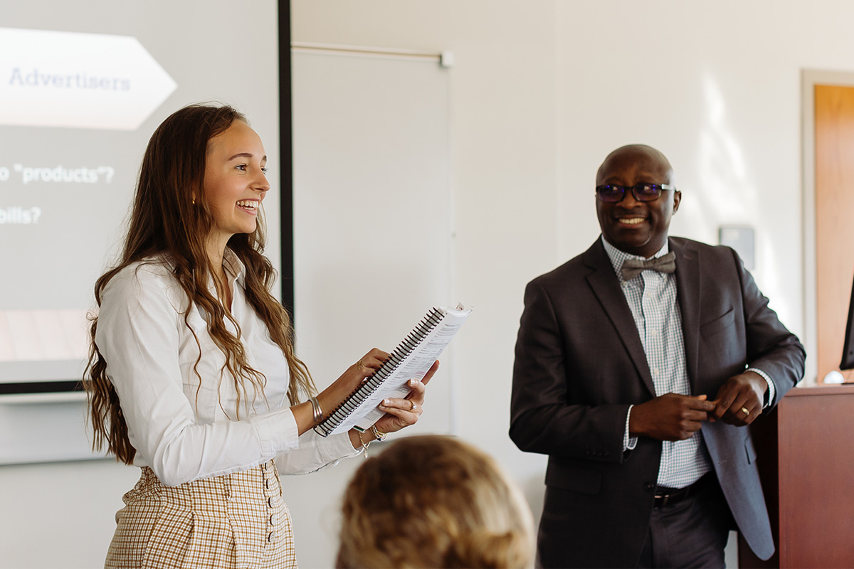 a student happily presenting to an attentive class
