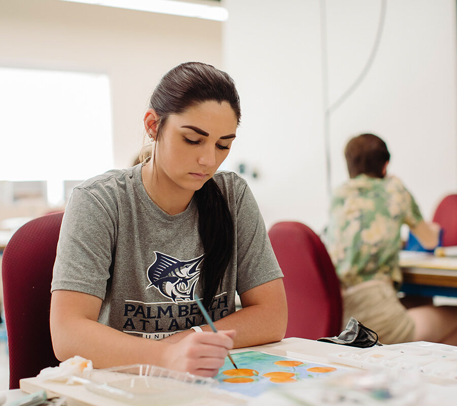 an art education student painting at a table