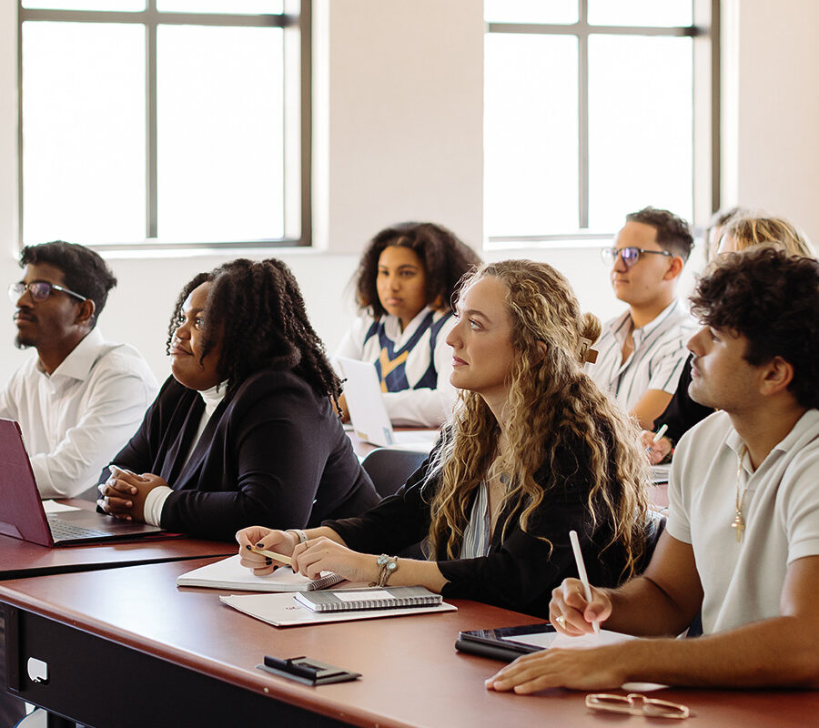 a group of students sitting in a classroom listening to a lecture