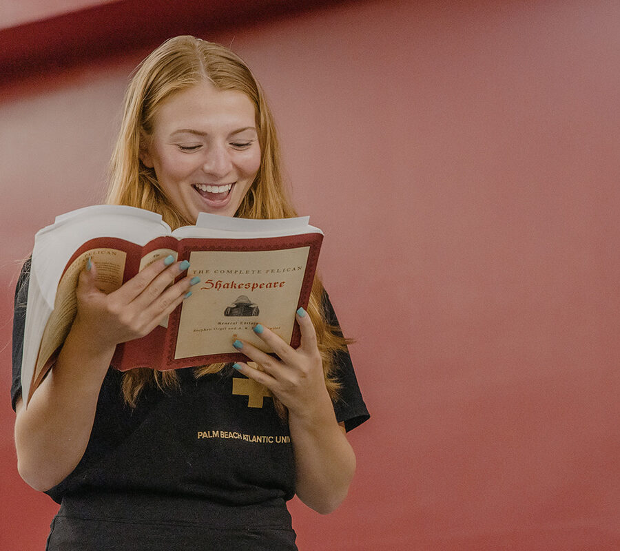 A student reading a book and smiling
