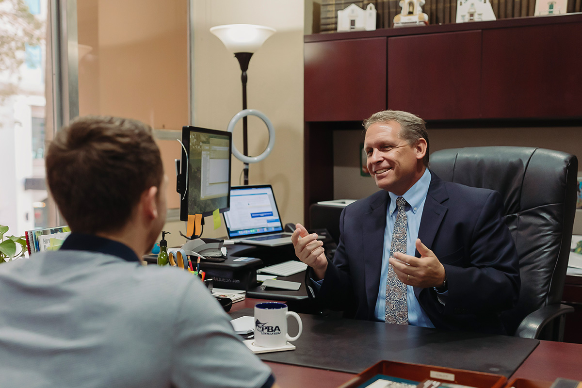 a faculty member speaking to a student in their office