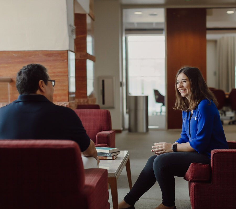 a student sitting in the library meeting with an admissions counselor