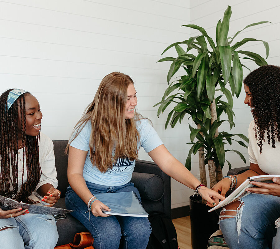 Three PBA students study together on campus.