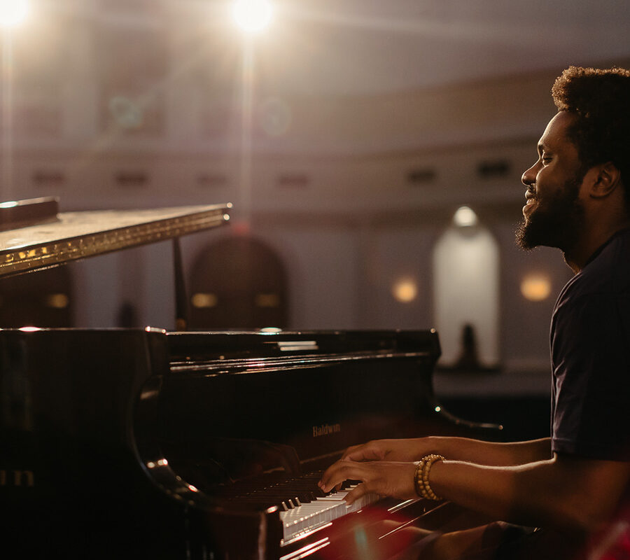 a keyboard performance major playing piano in a chapel